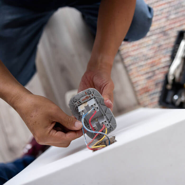 an electrician fixing an electrical outlet