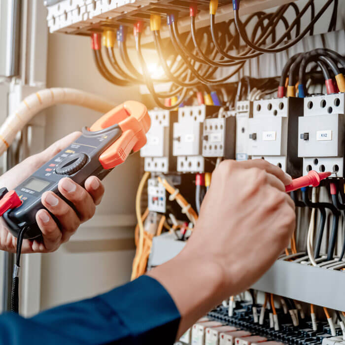 Electrician engineer uses a multimeter to test the electrical installation and power line current