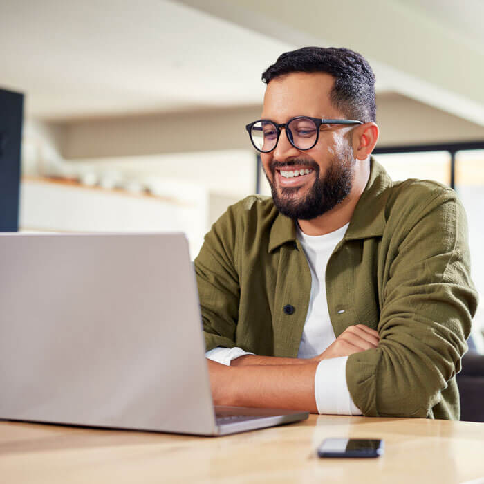 young adult man working on self-paced NEC certification course on laptop at home